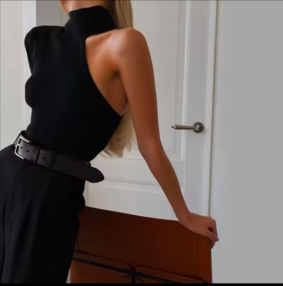 Schwarzes, asymmetrisches One-Shoulder Strick-Top mit hohem Kragen. Figurbetonte Passform, ideal für elegante und moderne Looks.