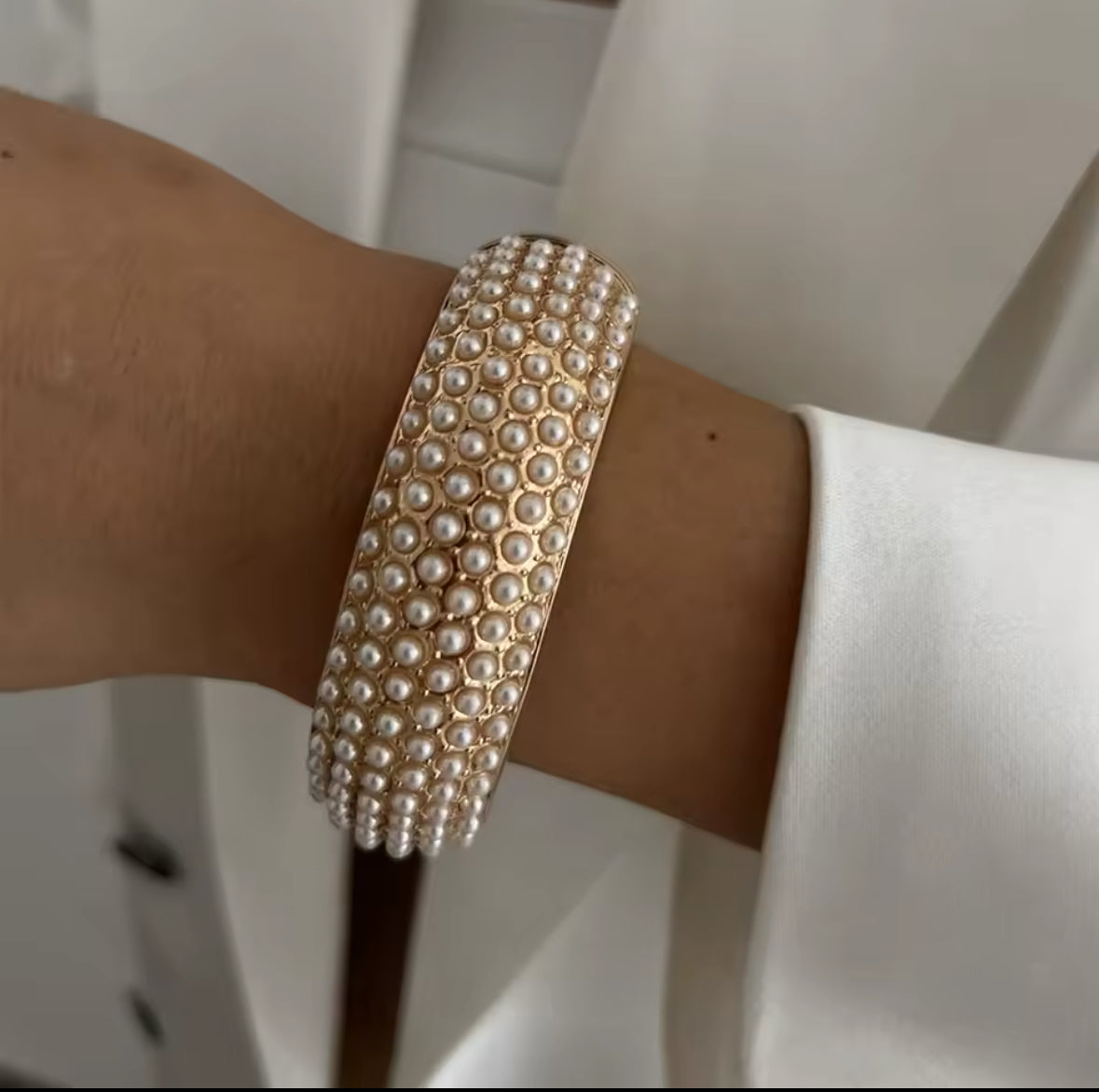 Luxuriöses Perlenarmband mit dicht gesetzten, glänzenden Perlen auf einer goldenen Basis. Elegantes Statement-Schmuckstück für besondere Anlässe, Abendgarderobe und stilvolle Outfits. Hochwertige Verarbeitung für einen zeitlosen, femininen Look.