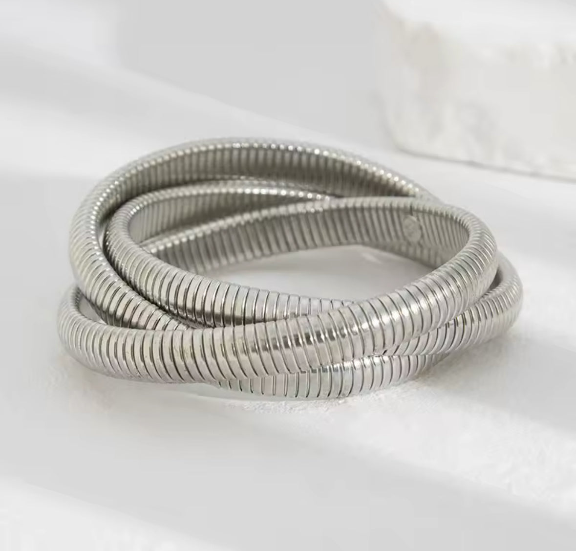 Elegantes Armreif-Set in Silber mit mehreren strukturierten Armreifen, offener Spange mit Perlen und glänzend geformtem Armreif – moderner, minimalistischer Statement-Schmuck.