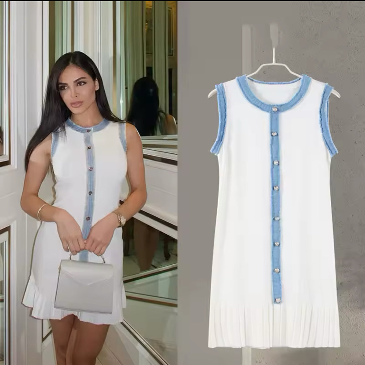 Ärmelloses, cremeweißes Minikleid mit goldener Knopfleiste, blauen Fransen-Details und plissiertem Saum – elegant gestylt mit Tasche und Heels, aufgenommen vor einem verspiegelten Interior.