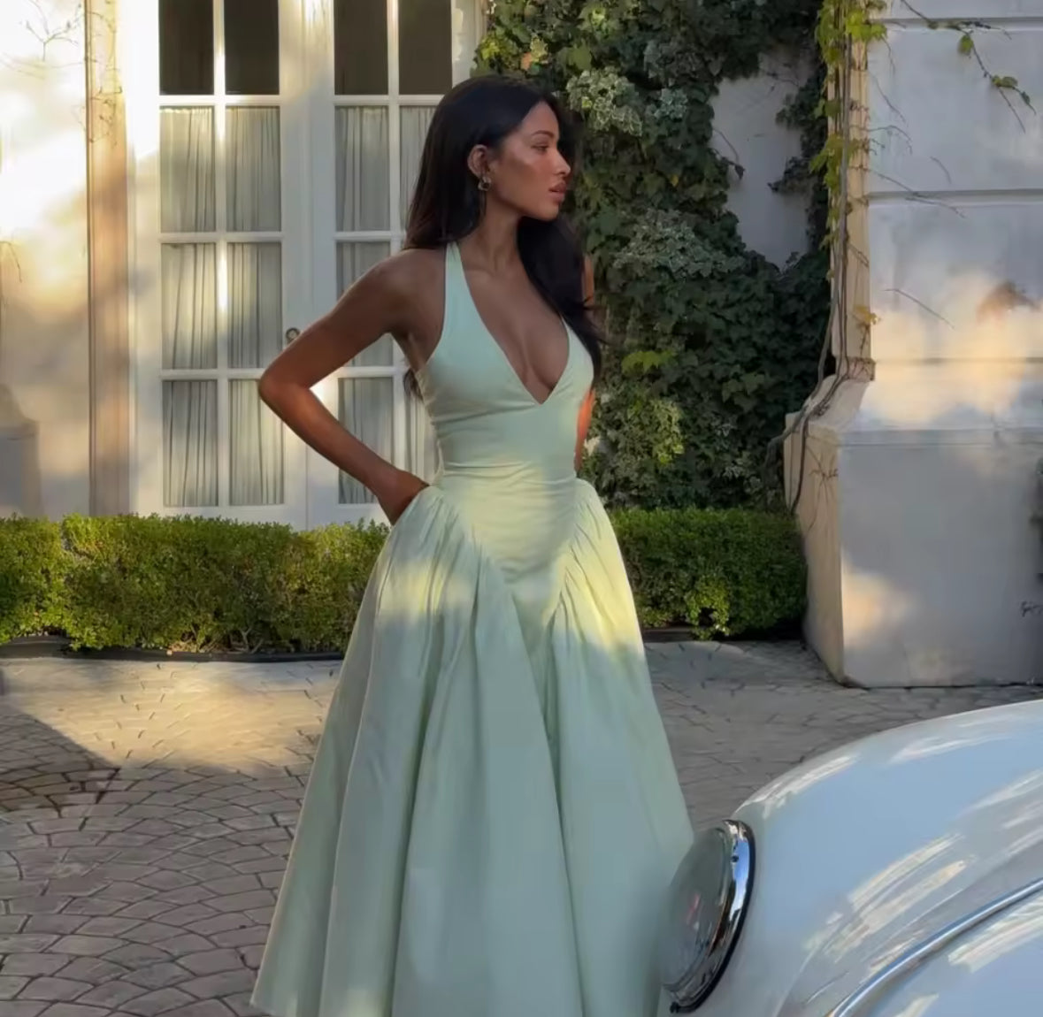 Rückenfreies Halterneck-Kleid in Pastellgrün mit V-Ausschnitt, schwingendem Midirock und fester Passform im Brustbereich – elegantes Sommerkleid für besondere Anlässe.