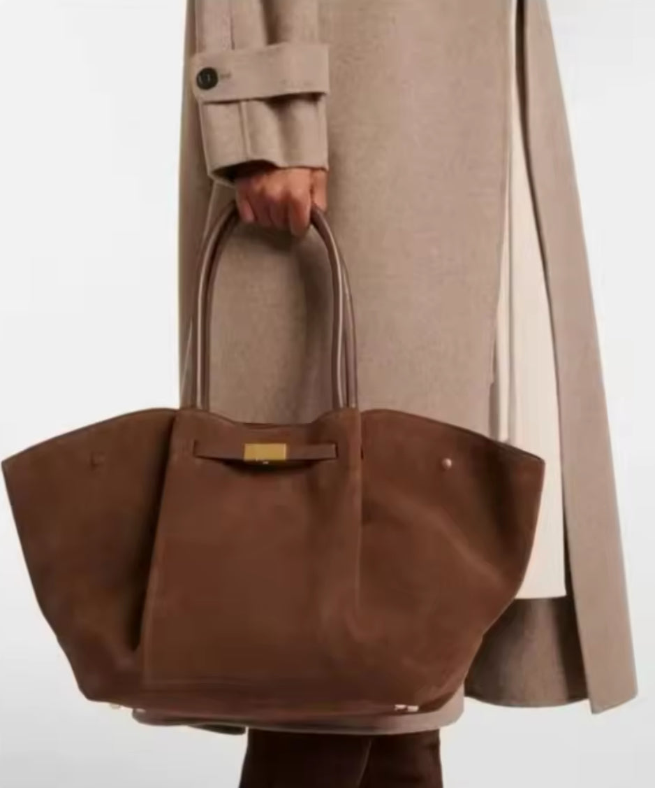 Elegante, große Handtasche mit luxuriöser Wildleder-Optik und goldenen Details. Verfügbar in Schwarz, Dunkelbraun und Cognacbraun. Perfekt für einen stilvollen, zeitlosen Look – ideal für Business und Alltag.
