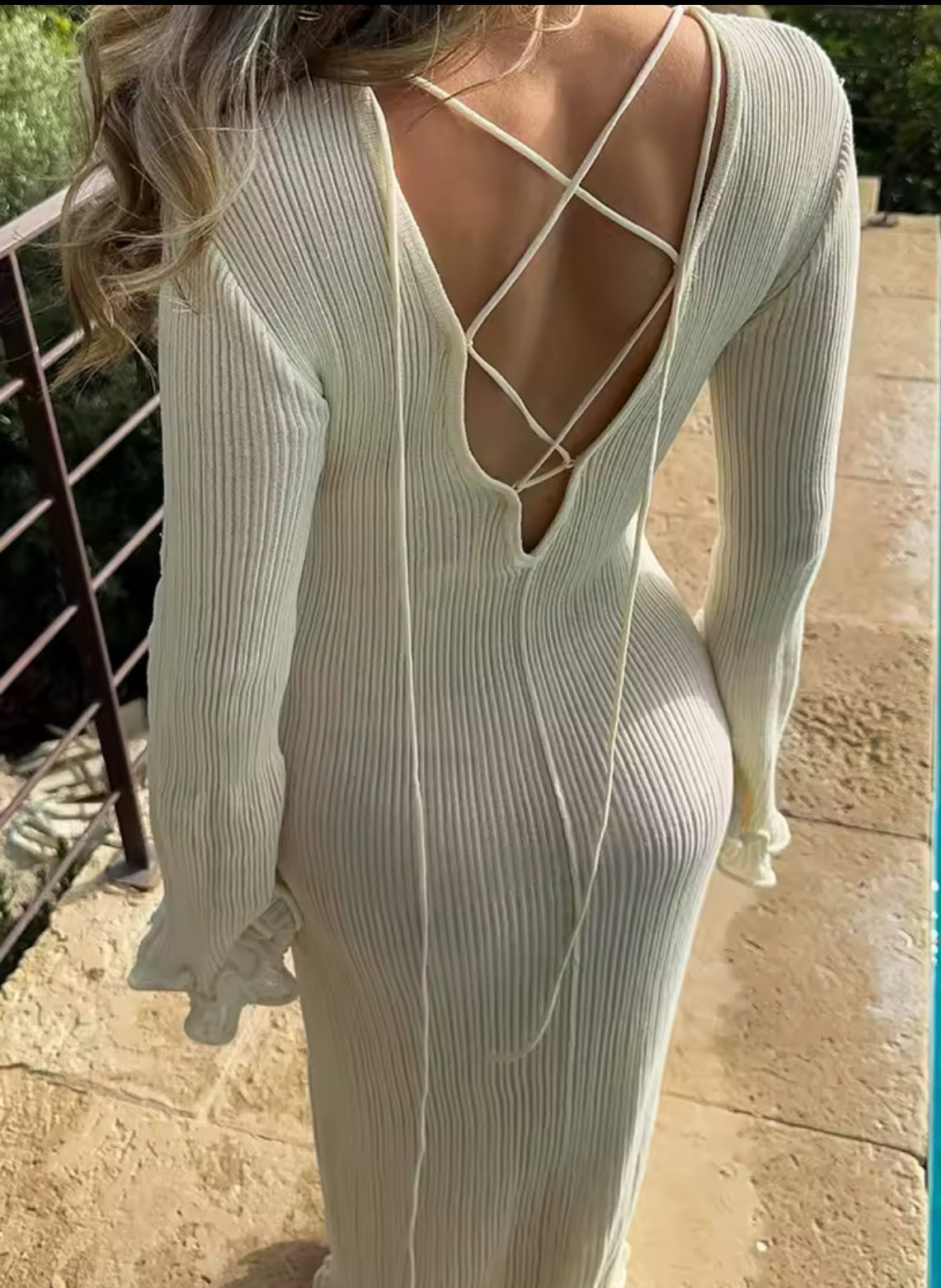 Elegantes Maxikleid in Cremeweiß mit verspieltem Rückendetail und Schnürung. Weit geschnittene Ärmel und wellenförmige Säume für einen romantischen, femininen Look. Kombiniert mit einer edlen Strohtasche – perfekt für stilvolle Sommer- und Frühlings-Outfits.