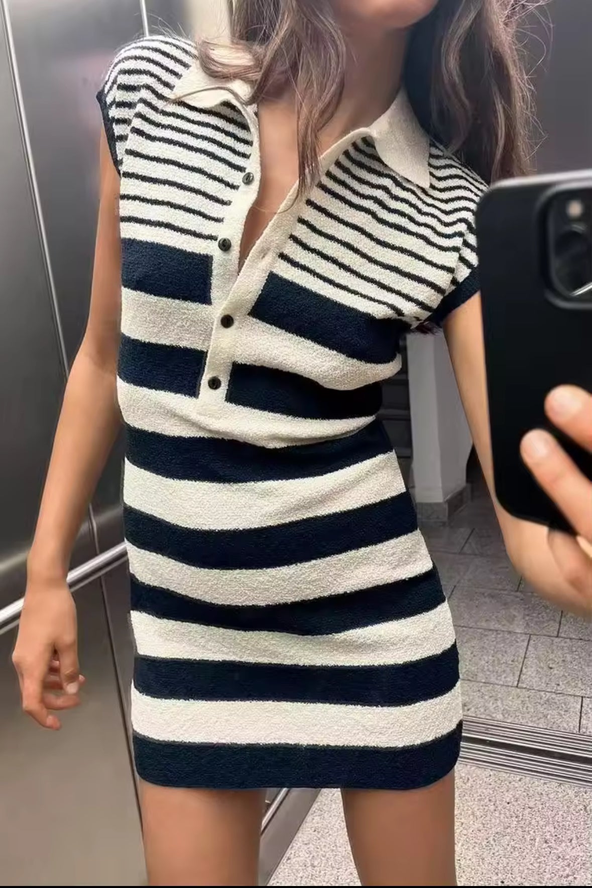 Ärmelloses, figurbetontes Minikleid mit navyblauen und cremeweißen Streifen, Polokragen und Knopfleiste aus strukturiertem Strickstoff – aufgenommen als Spiegelselfie in einem Aufzug.