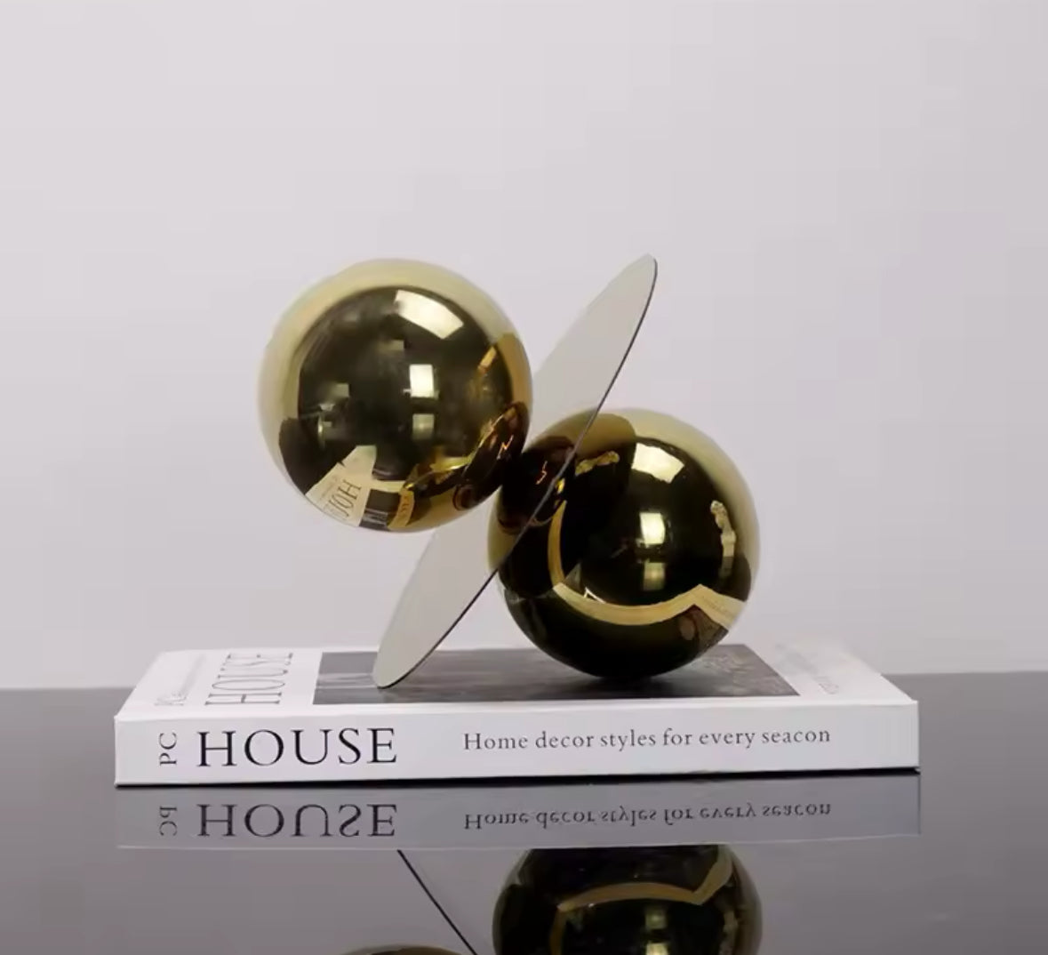 Moderne Designer-Skulptur aus glänzendem Metall mit geometrischer Balance aus Kugeln und Platte in edlem Gold. Perfekt für stilvolle Wohn- und Arbeitsräume