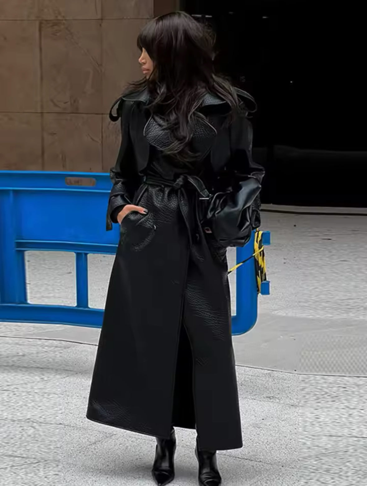 Eleganter Trenchcoat aus schwarzem Leder mit markantem Kragen und Taillengürtel. Strukturierte Oberfläche und raffinierte Schnittführung für einen zeitlosen, stilvollen Look. Ideal für modische Herbst- und Winter-Styles.