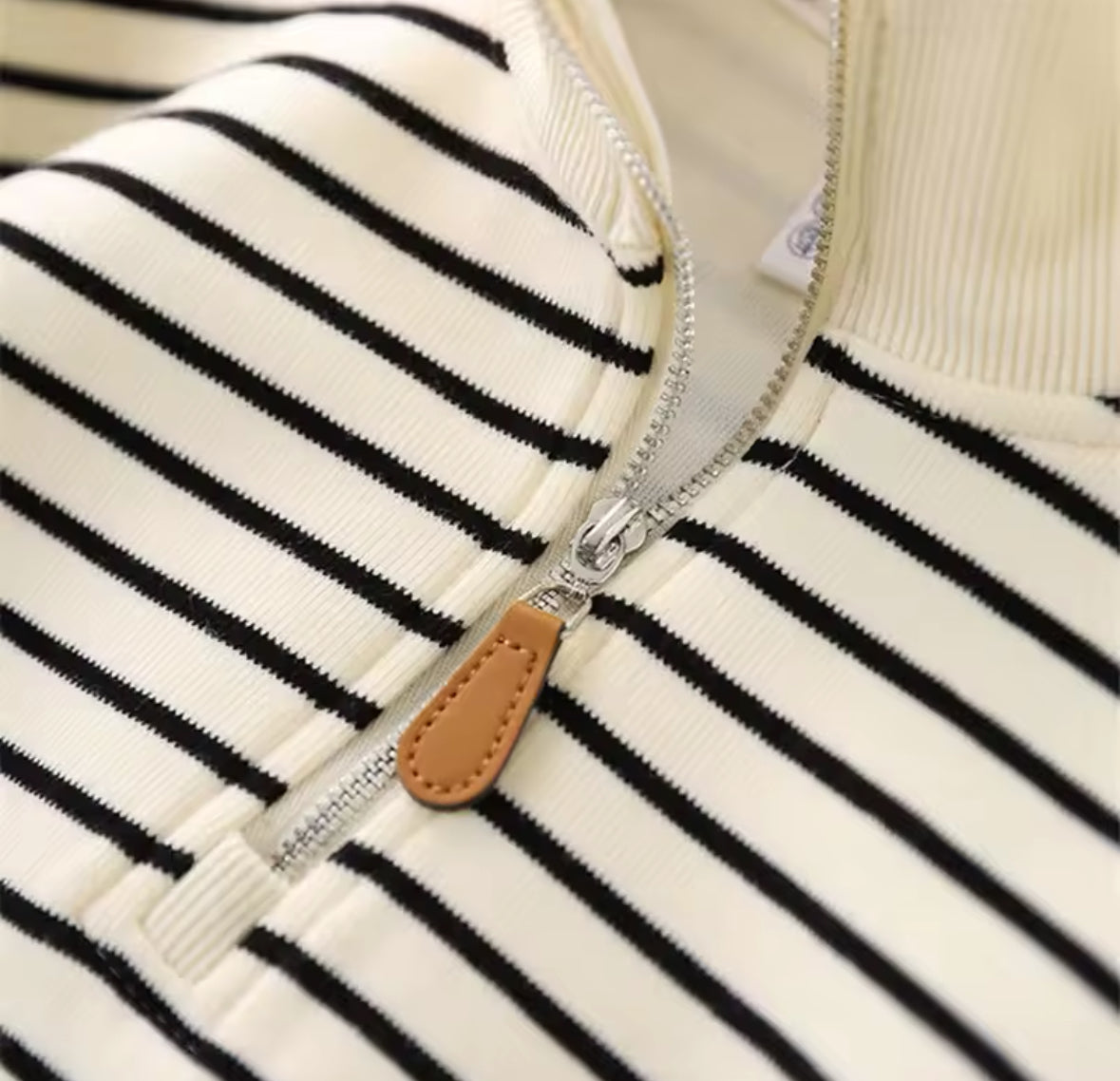 Nahaufnahme des Reißverschluss-Details mit Lederanhänger.