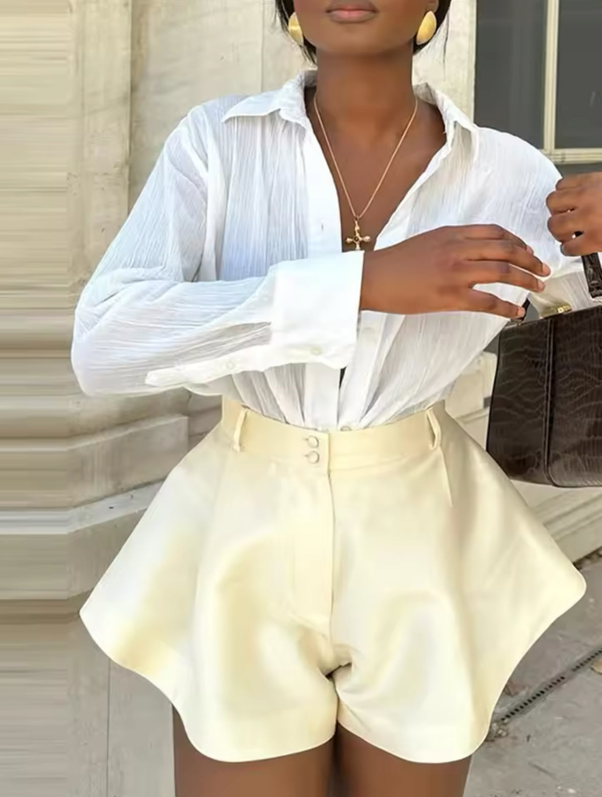 Écru Satin-Shorts mit A-Linien-Schnitt, perfekt gestylt mit einer klassischen Bluse und goldenen Schmuck-Details für einen zeitlosen Chic.