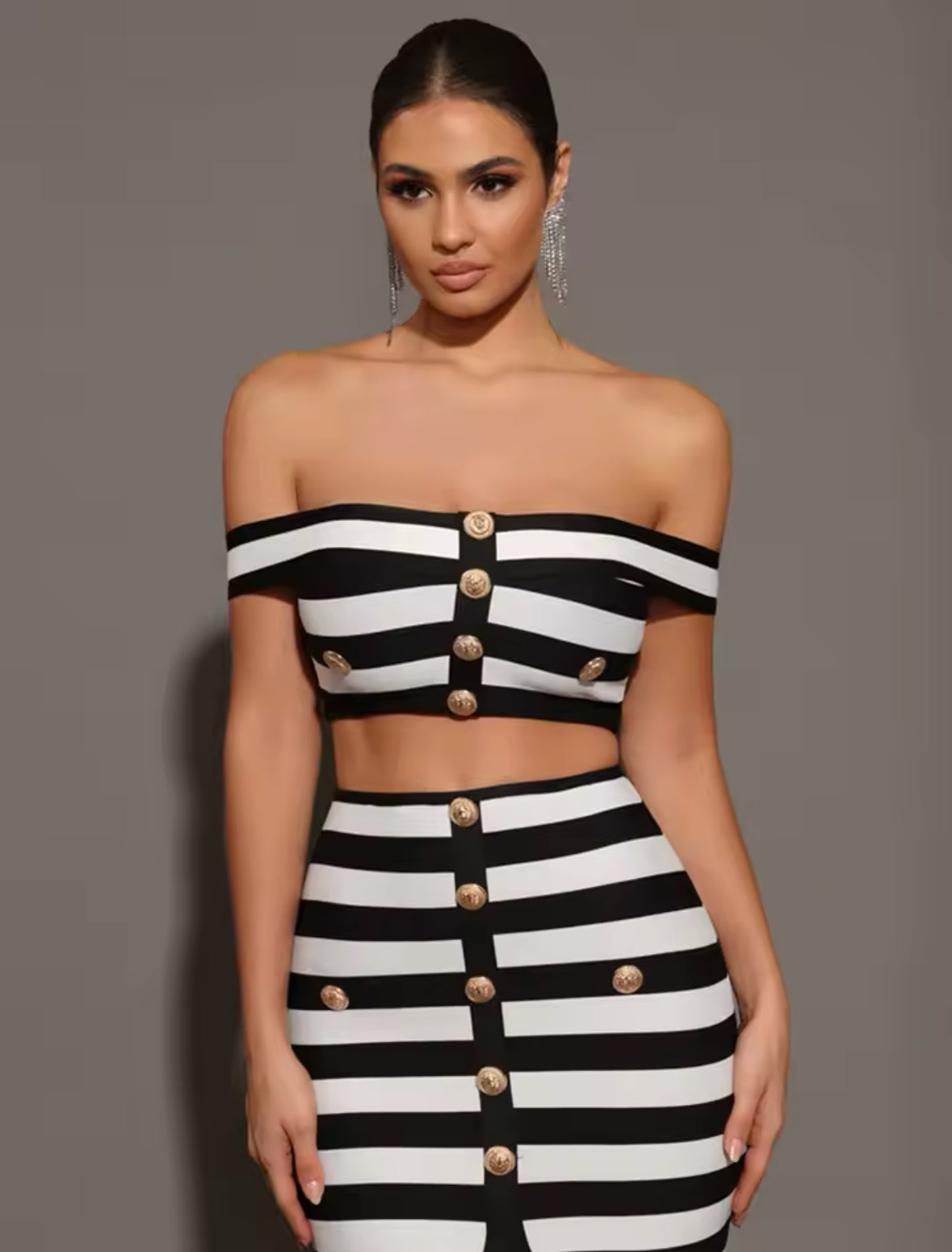 Model trägt elegantes Schwarz-Weiß-Zweiteiler-Set mit Off-Shoulder-Top und goldenen Knöpfen – Designer-inspirierter Statement-Look