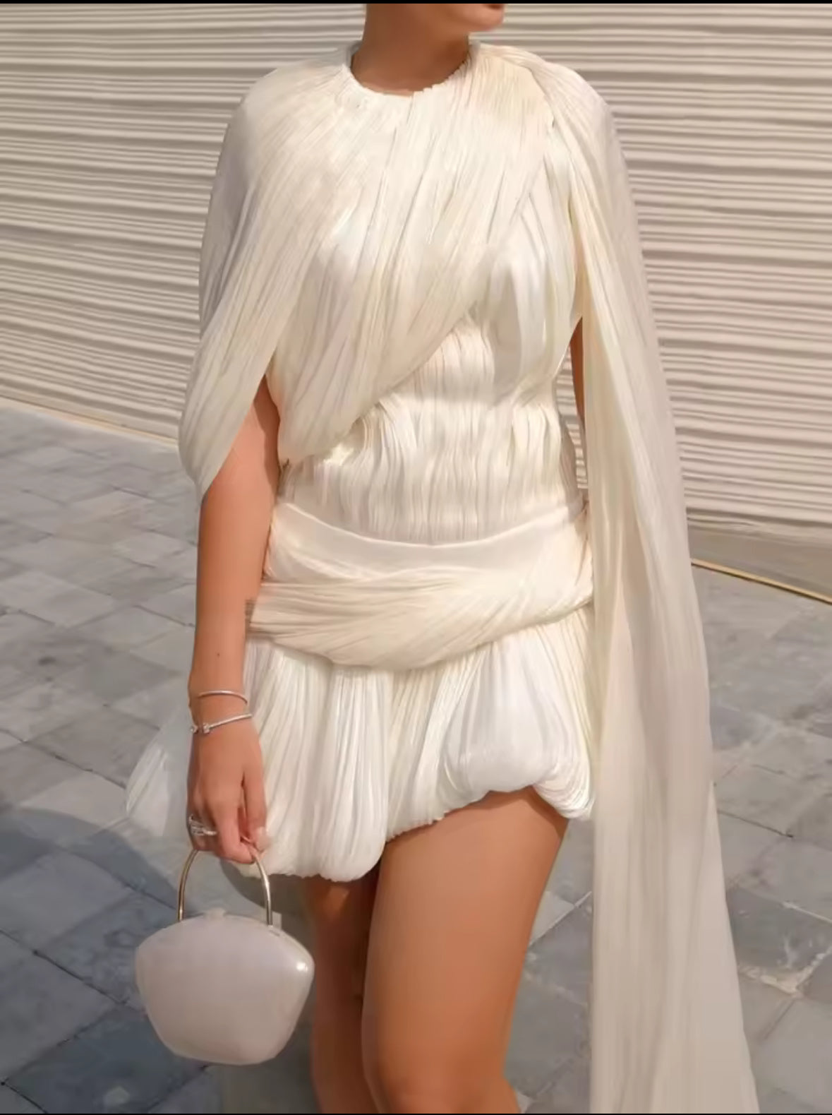 Asymmetrisches elfenbeinweißes Kleid mit Drapierung und Cape-Detail, plissiert und ballonförmiger Minirock