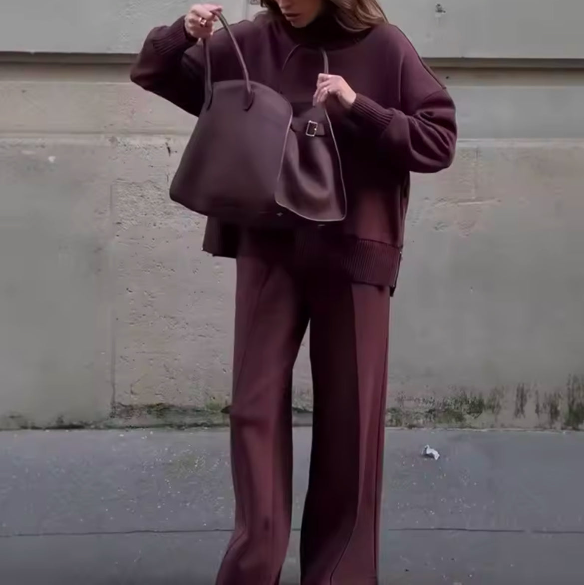Monochromes Set in Bordeaux mit Oversize-Pullover und weit geschnittener Hose. Lässiger und dennoch eleganter Look aus hochwertigem Strickstoff für maximalen Tragekomfort. Perfekt für stilvolle Casual- und Streetstyle-Outfits mit minimalistischer Ästhetik.