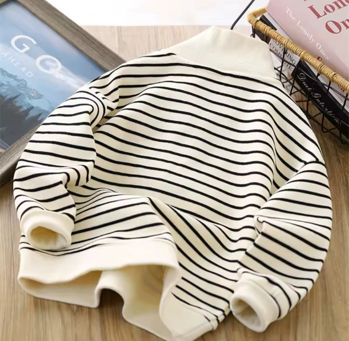 Rückansicht des cremefarbenen Sweaters mit schwarzen Streifen.