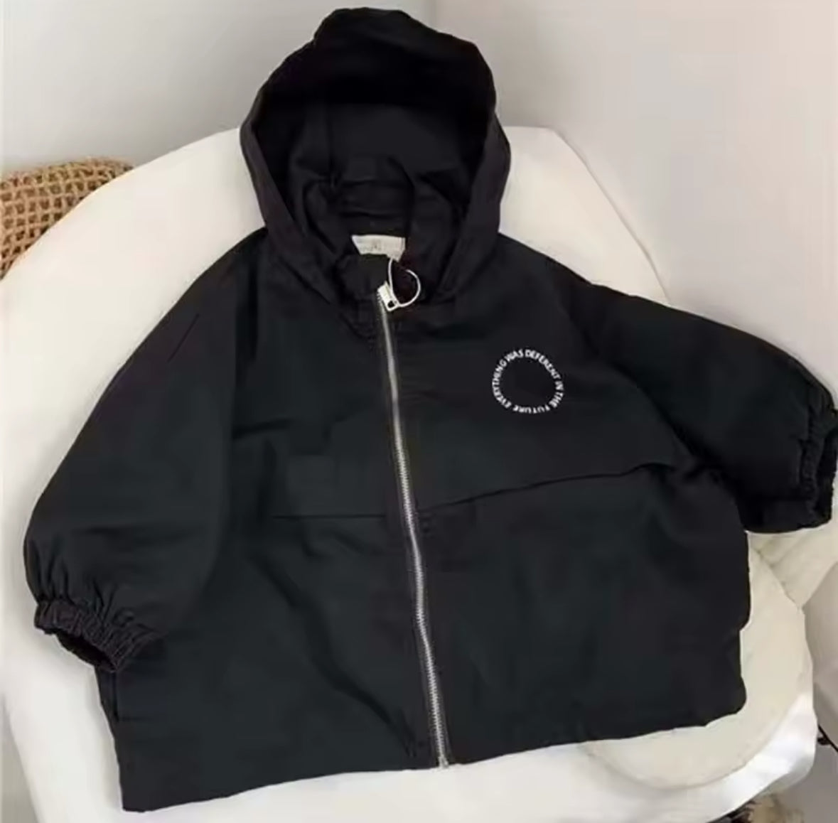 Detailaufnahme der Vorderseite der Jacke mit modernem Rundschrift-Print