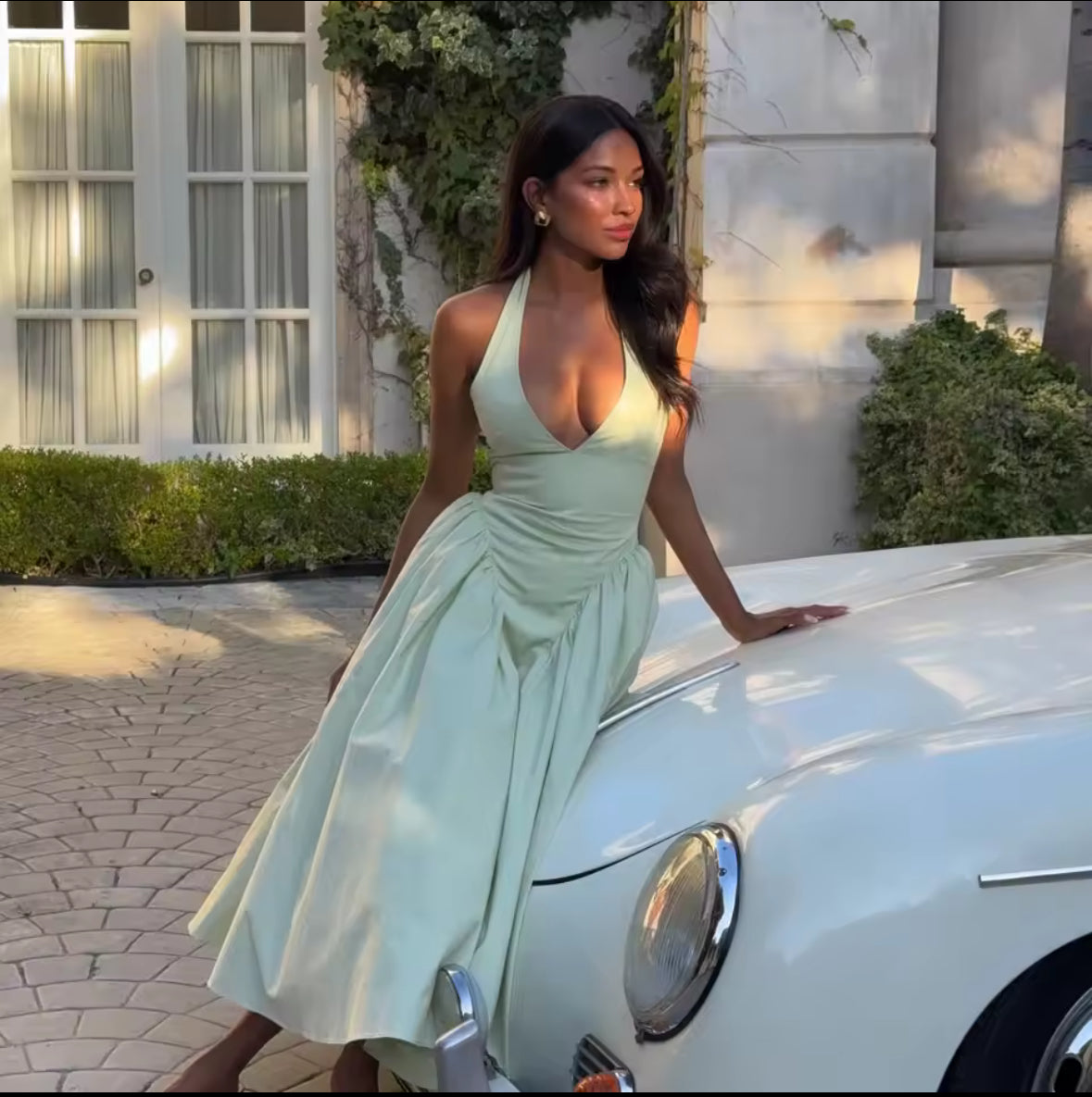Rückenfreies Halterneck-Kleid in Pastellgrün mit V-Ausschnitt, schwingendem Midirock und fester Passform im Brustbereich – elegantes Sommerkleid für besondere Anlässe.