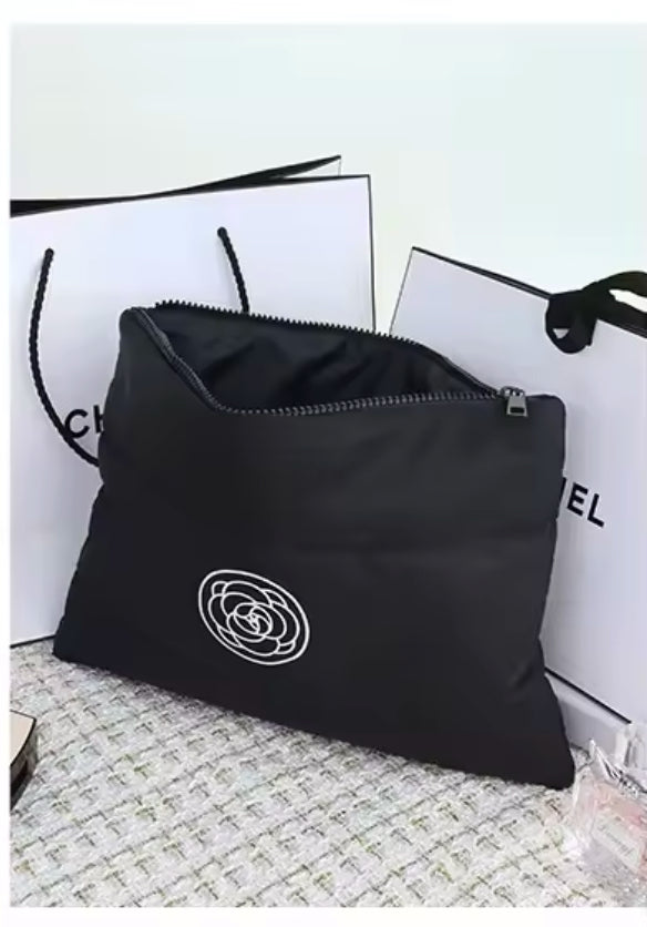 Zwei stilvolle Kosmetiktaschen in Schwarz und Creme mit wattierter Oberfläche und einem minimalistischen Rosen-Logo. Perfekt für die Aufbewahrung von Make-up und Pflegeprodukten unterwegs.