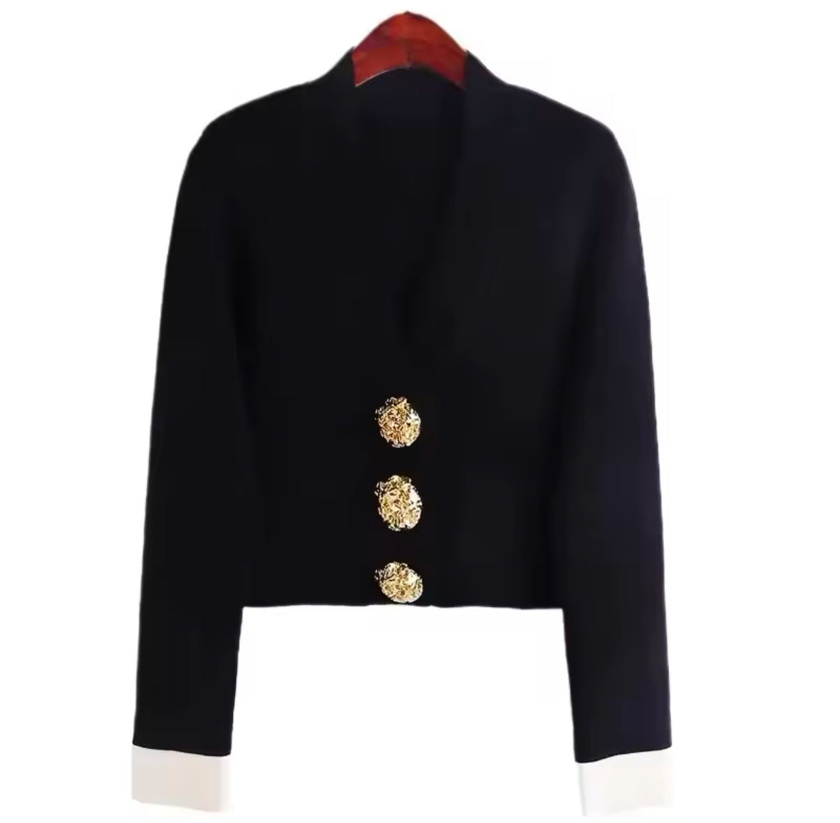 Eleganter schwarzer und weißer Cardigan mit V-Ausschnitt, goldenen Zierknöpfen und kontrastierenden Ärmelabschlüssen. Ein luxuriöses Statement-Piece für stilvolle Outfits.