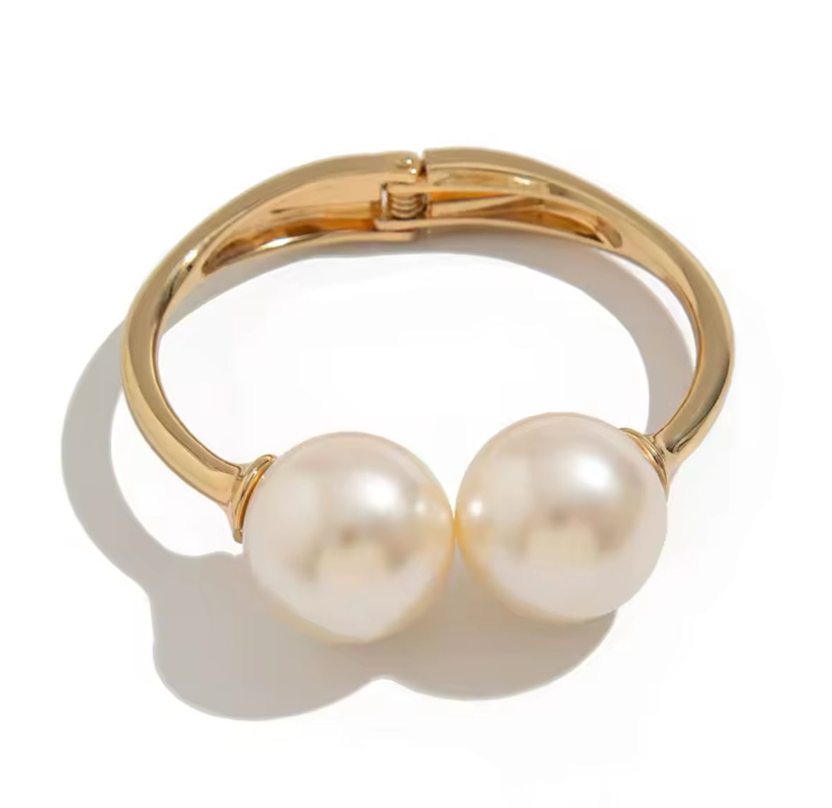 Luxuriöses Armreif-Set in Gold mit strukturierten Armreifen, glänzend geschwungener Armspange und offenem Armreif mit zwei großen Perlen – elegantes Statement-Schmuckstück.