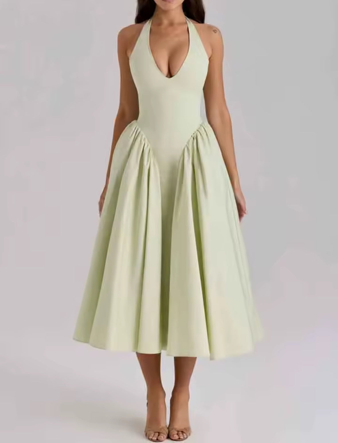 Rückenfreies Halterneck-Kleid in Pastellgrün mit V-Ausschnitt, schwingendem Midirock und fester Passform im Brustbereich – elegantes Sommerkleid für besondere Anlässe.