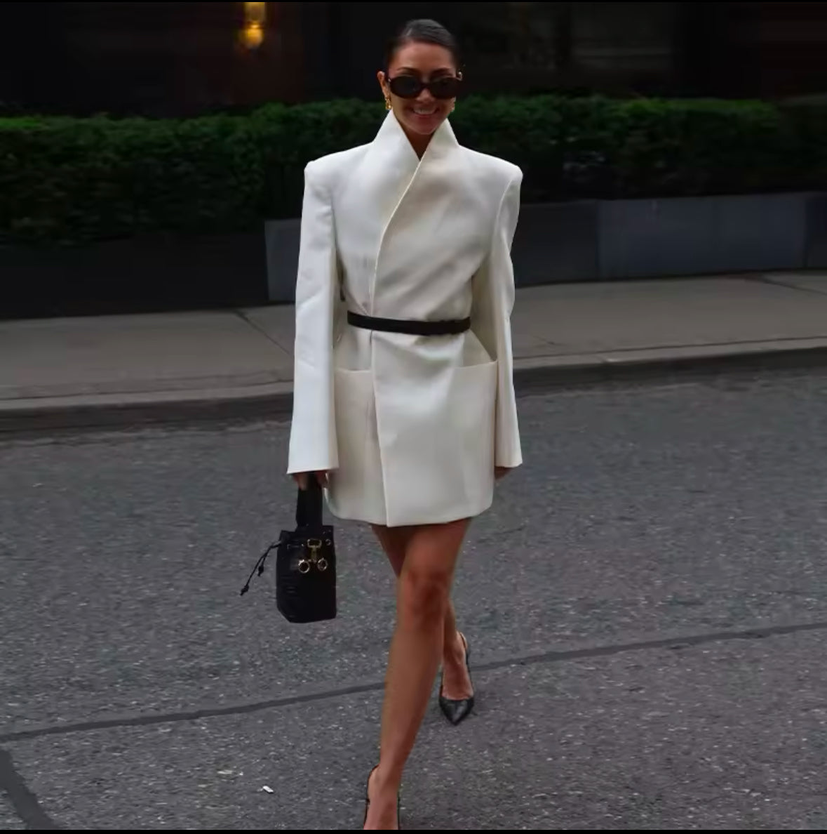 Elegantes Blazerkleid in Cremeweiß mit minimalistischer Silhouette und strukturiertem Kragen. Tailliert mit einem schwarzen Gürtel für eine feminine, moderne Passform. Kombiniert mit schwarzen High Heels und edler Handtasche – perfekter Power-Look für Business und Events.