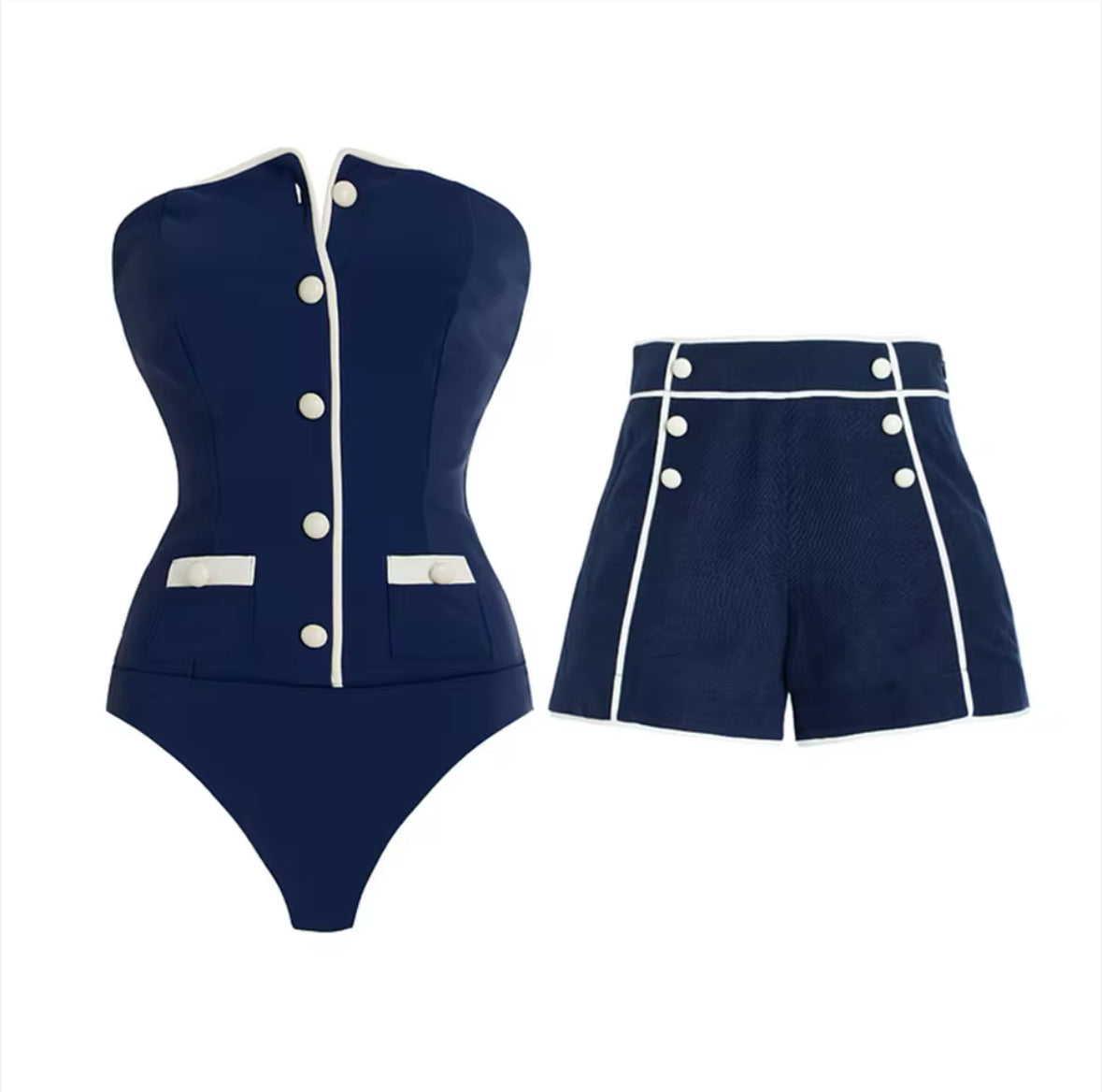 Zweiteiliges Set bestehend aus einem navyblauen Badeanzug mit weißen Kontrastdetails und dekorativen Knöpfen, kombiniert mit passenden High-Waist-Shorts – getragen von einem Model