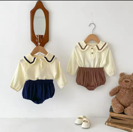 Zwei Baby-Zweiteiler in Beige mit braunen & blauen Details, inklusive Shorts.