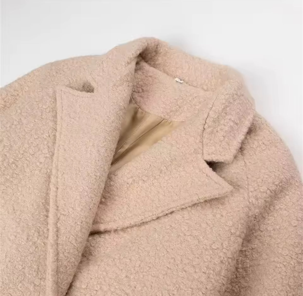 Luxuriöser beiger Wollmantel mit Oversize-Schnitt, Bindegürtel und klassischen Revers, perfekt für elegante Winterlooks.