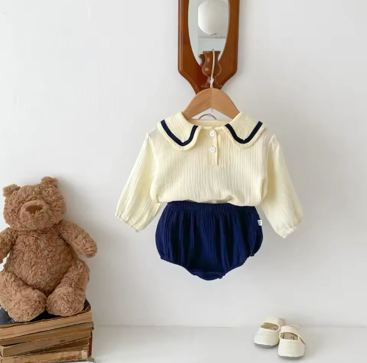 Beige Baby-Zweiteiler mit blauen  Akzenten, kombiniert mit kleinen Schuhen.