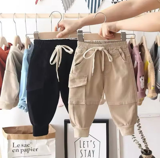 Zwei Cargo-Jogginghosen für Kinder in Beige und Schwarz mit Kordelzug.