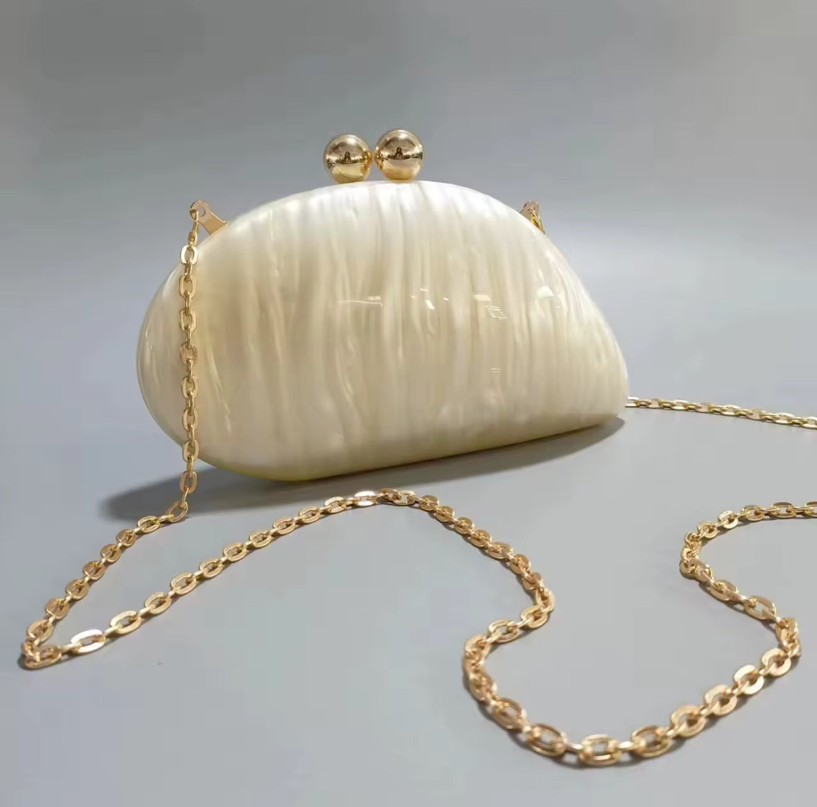 Perlweiße Clutch mit goldenem Kugelverschluss