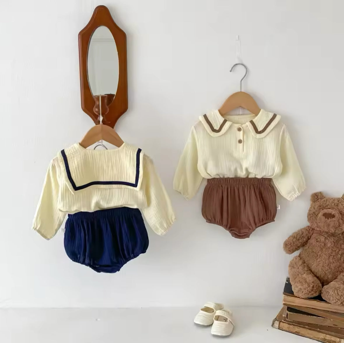 Zwei Baby-Zweiteiler in Beige mit braunen & blauen Details, inklusive Shorts.