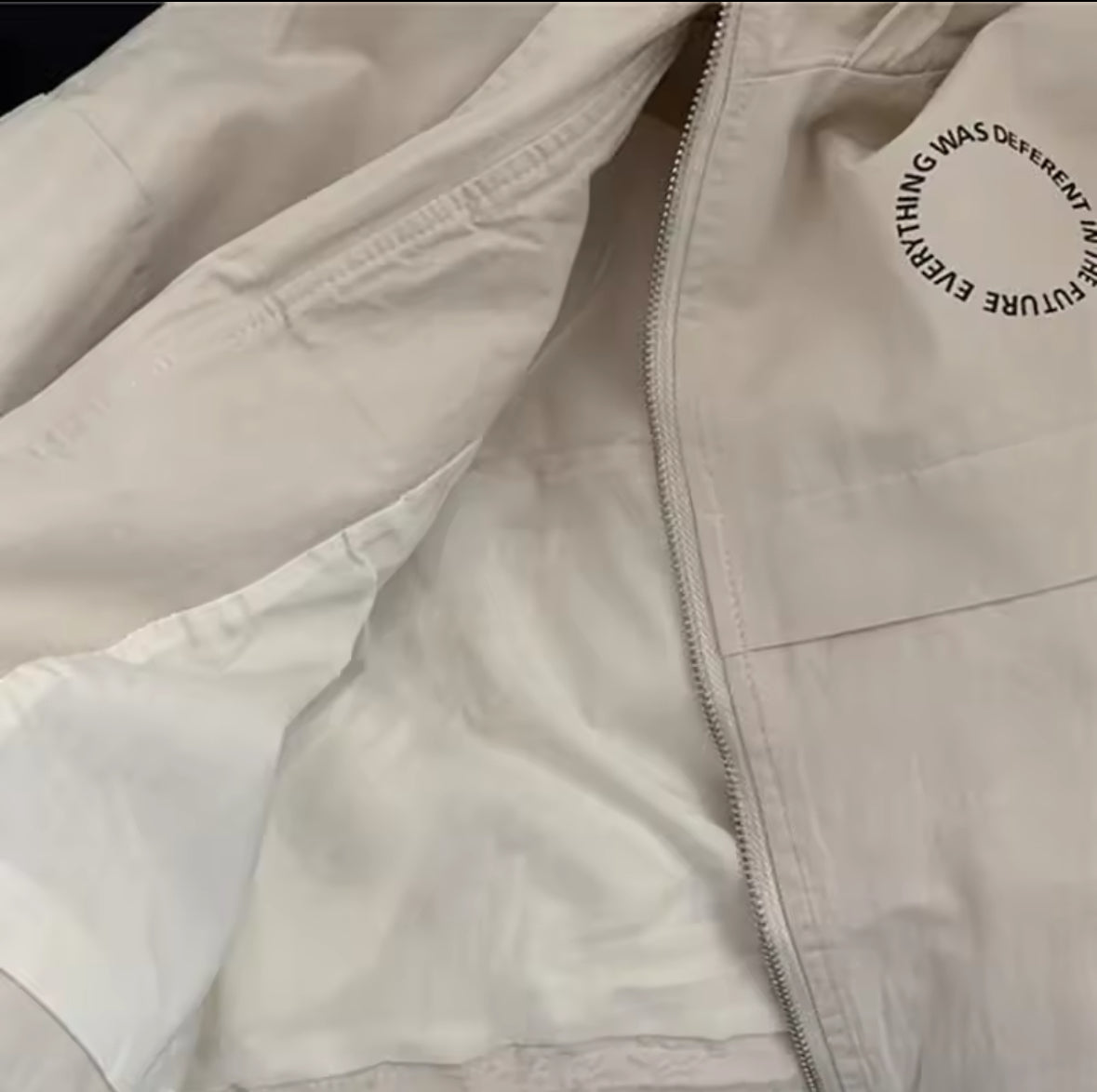 Detailaufnahme der Vorderseite der Jacke mit modernem Rundschrift-Print