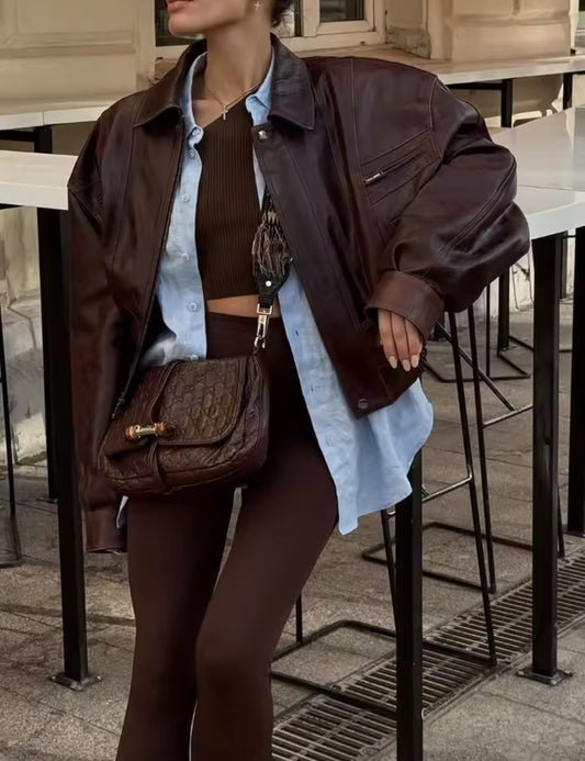 Frau trägt die Brooklyn Jacket – eine oversized Lederjacke in dunklem Braun mit Vintage-Charakter, kombiniert mit casual und eleganten Outfits.
