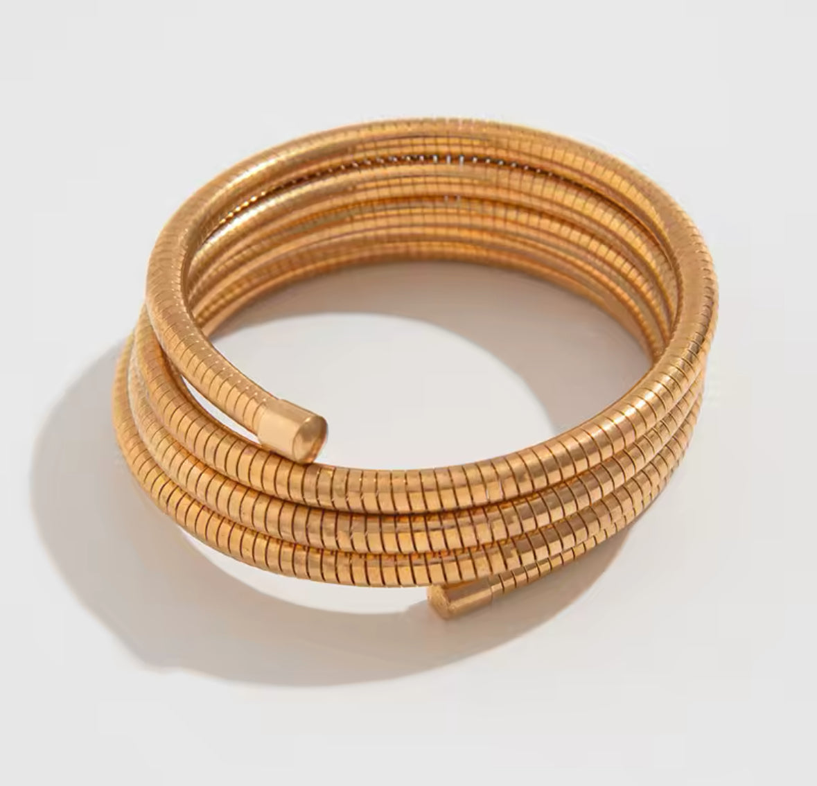 Luxuriöses Armreif-Set in Gold mit strukturierten Armreifen, glänzend geschwungener Armspange und offenem Armreif mit zwei großen Perlen – elegantes Statement-Schmuckstück.