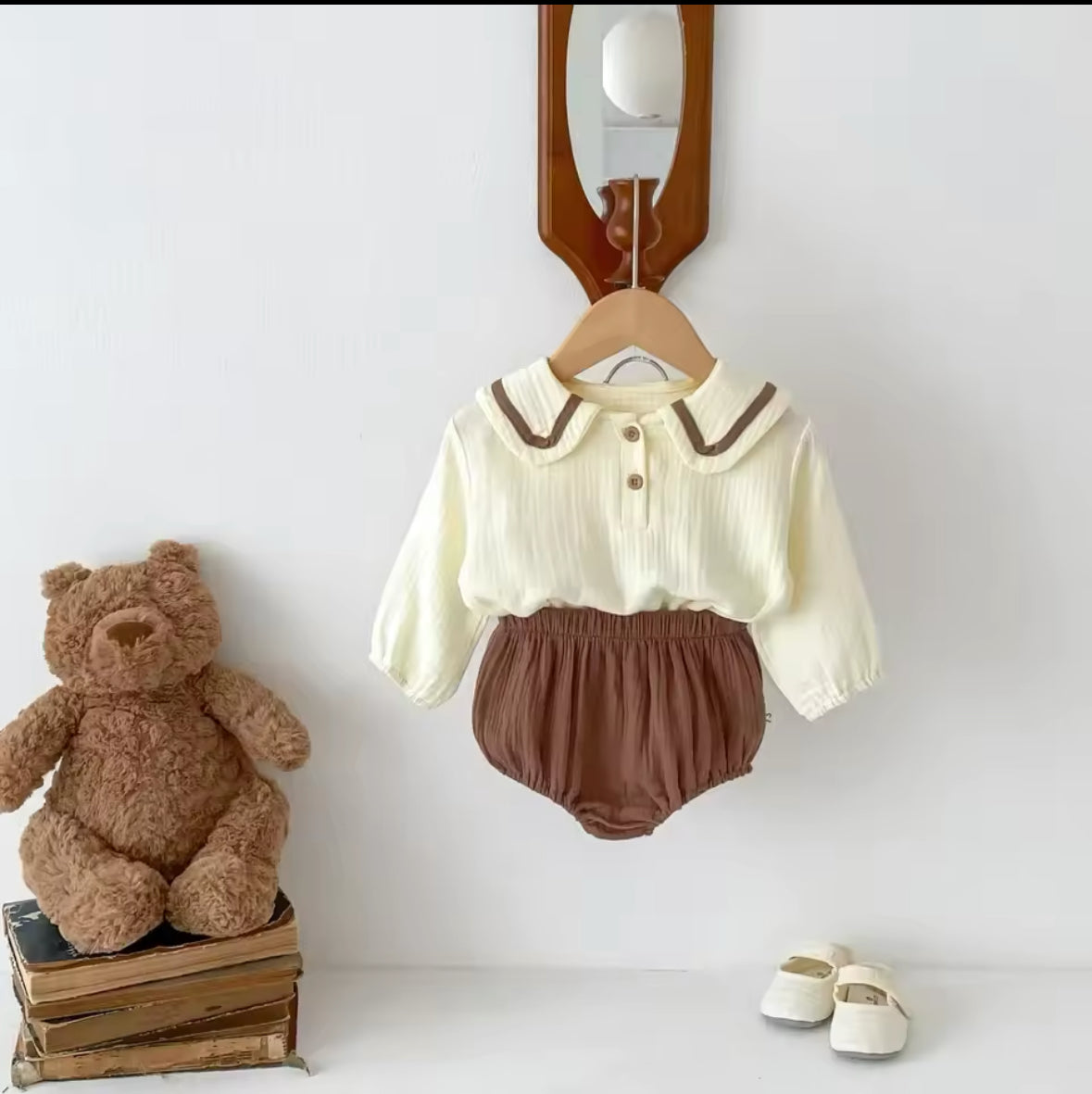 Beige Baby-Zweiteiler mit braunen Akzenten, kombiniert mit kleinen Schuhen.