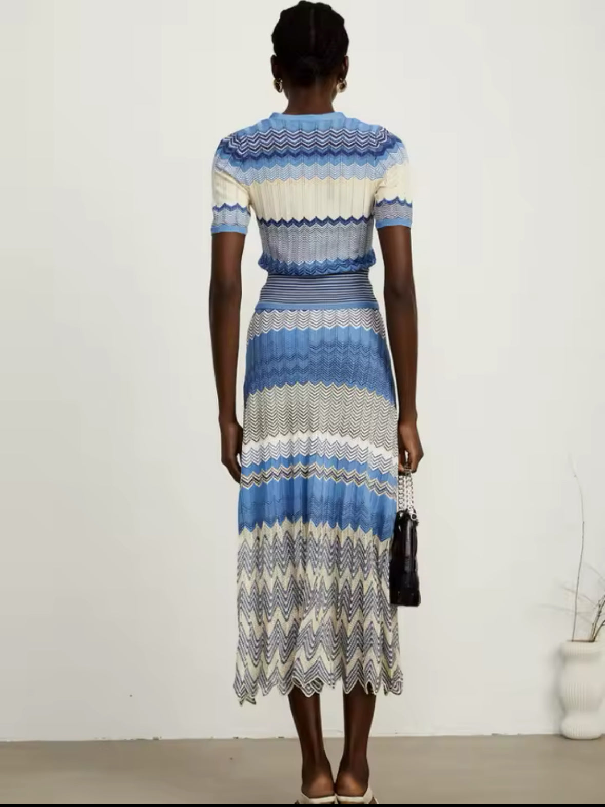 Edles Strick-Midikleid mit V-Ausschnitt, Knopfleiste und kunstvollem Zickzack-Muster in Blautönen. Perfekt für elegante Sommer-Looks.