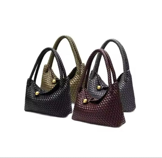 Vier luxuriöse Handtaschen in Flechtoptik in den Farben Schwarz, olivgrün, Bordeaux und Anthrazit, elegant präsentiert.