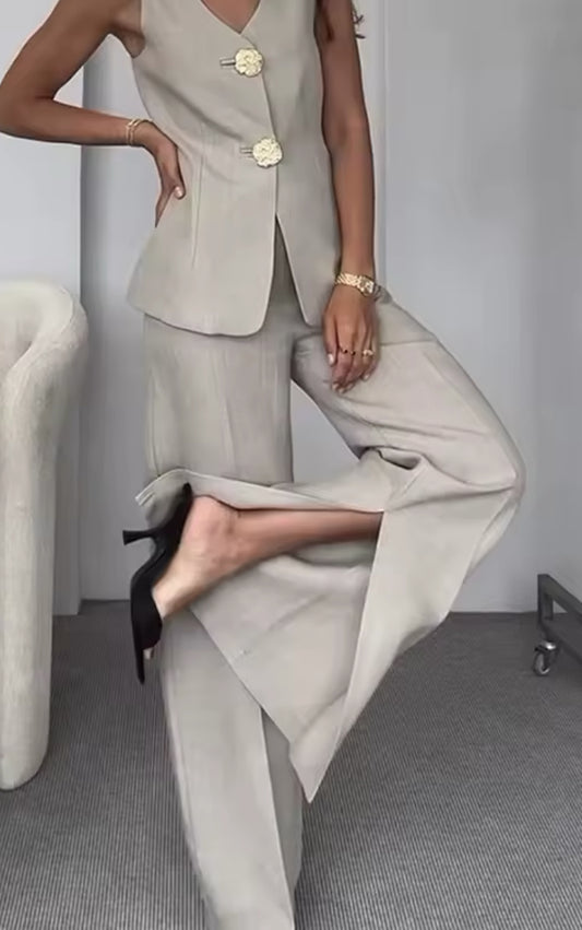 Goldene Statement-Knöpfe mit filigranem Design – hochwertiges Detail des beige-farbenen Damen-Hosenanzugs.