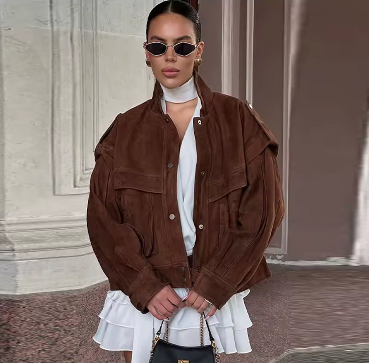Braune Mara Suède Oversize-Jacke kombiniert mit weißem Kleid und schwarzer Tasche – eleganter Streetstyle-Look.