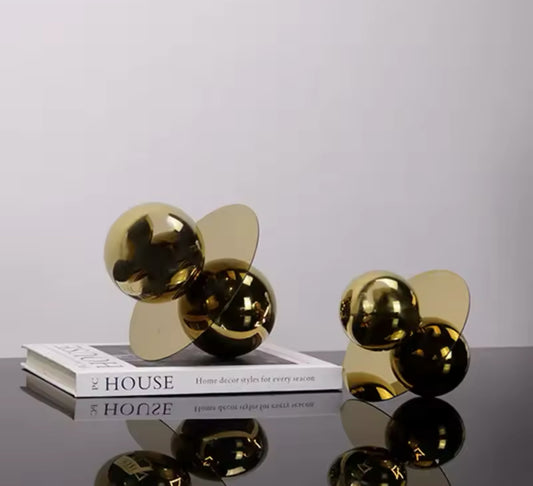 Moderne Designer-Skulptur aus glänzendem Metall mit geometrischer Balance aus Kugeln und Platte in edlem Gold. Perfekt für stilvolle Wohn- und Arbeitsräume