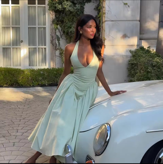 Rückenfreies Halterneck-Kleid in Pastellgrün mit V-Ausschnitt, schwingendem Midirock und fester Passform im Brustbereich – elegantes Sommerkleid für besondere Anlässe.
