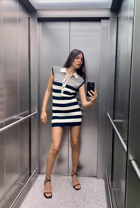 Ärmelloses, figurbetontes Minikleid mit navyblauen und cremeweißen Streifen, Polokragen und Knopfleiste aus strukturiertem Strickstoff – aufgenommen als Spiegelselfie in einem Aufzug.
